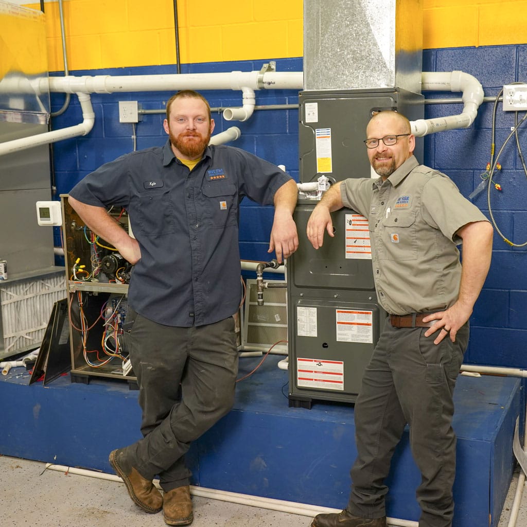 two techs next to furnace