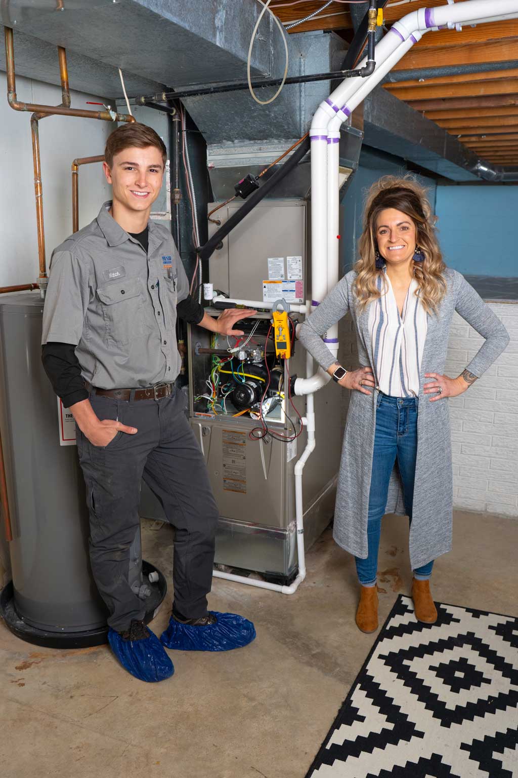 tech standing next to homeowner and furnace