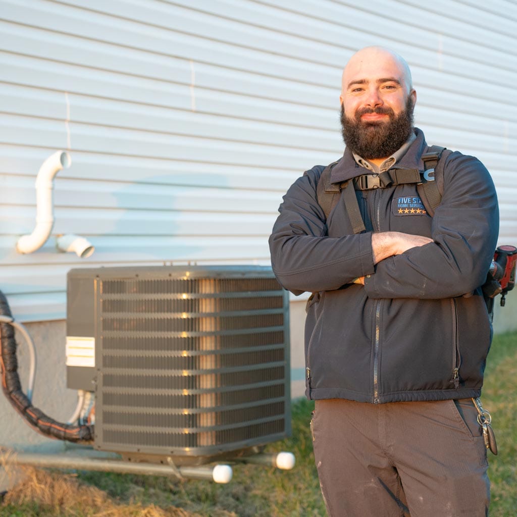 Technician standing next to air conditioner