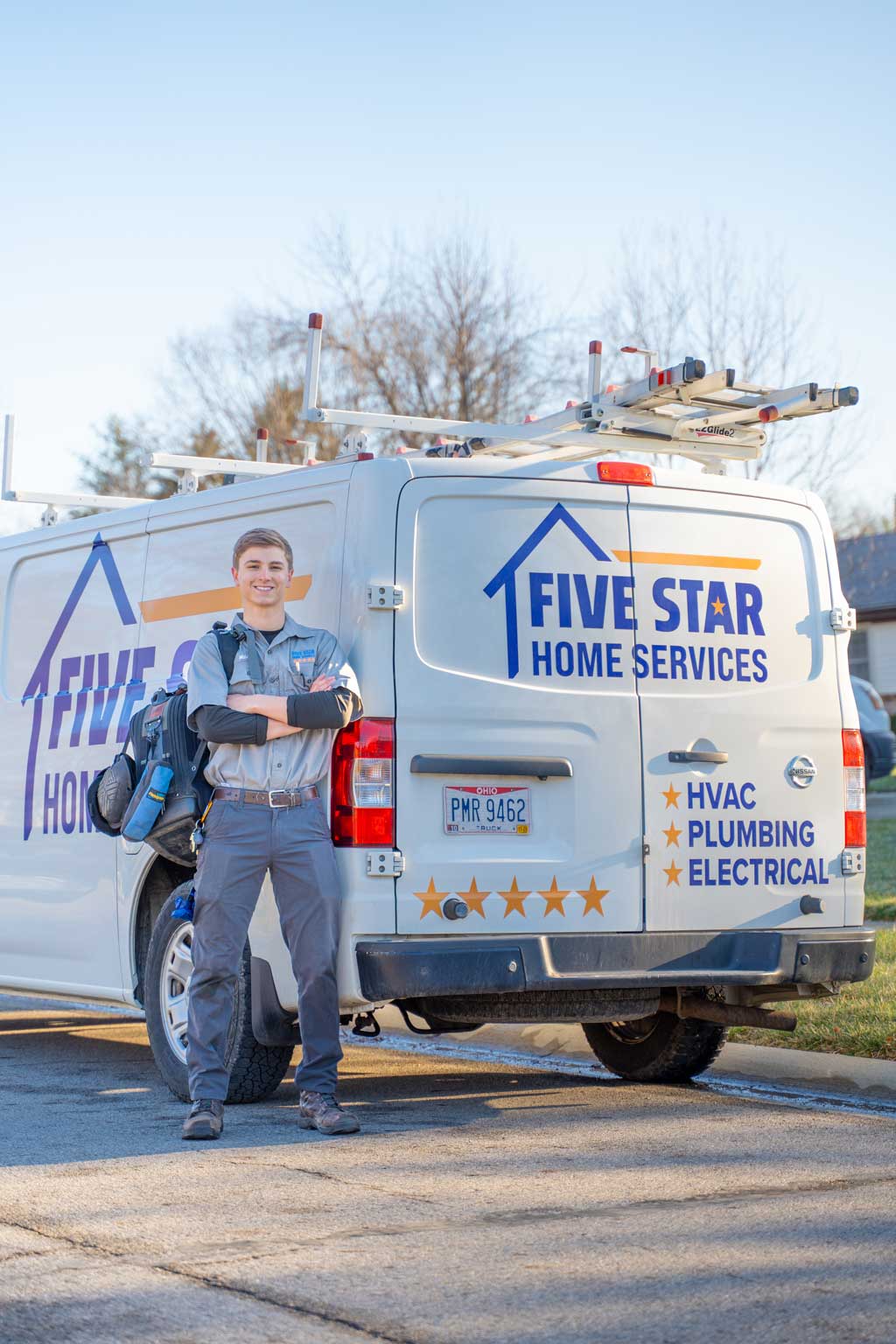 tech standing next to five star van