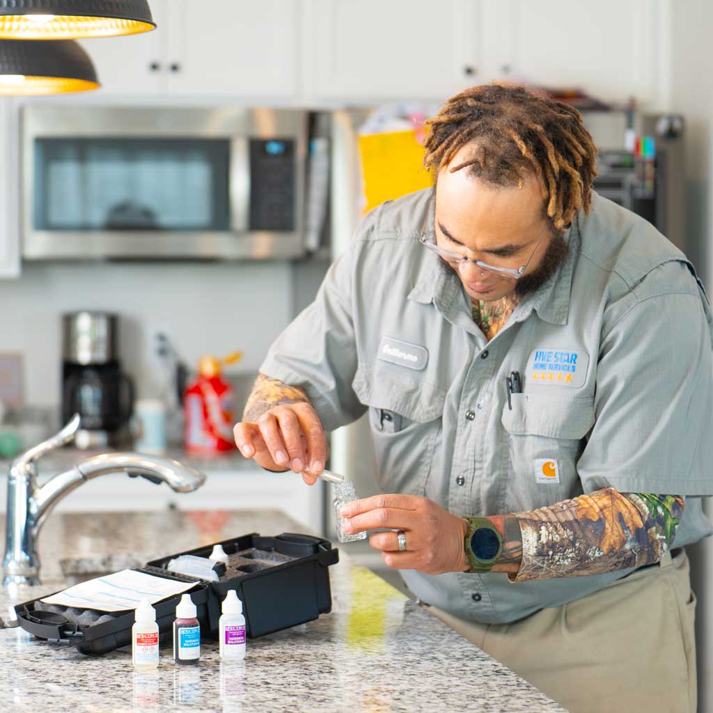 Five Star Home Services plumber performing a water quality test at a kitchen sink to determine if a carbon filter or other water treatment system is needed.
